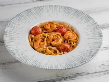 Тальятеле з тихоокеанськими креветками у соусі біск з томатами чері